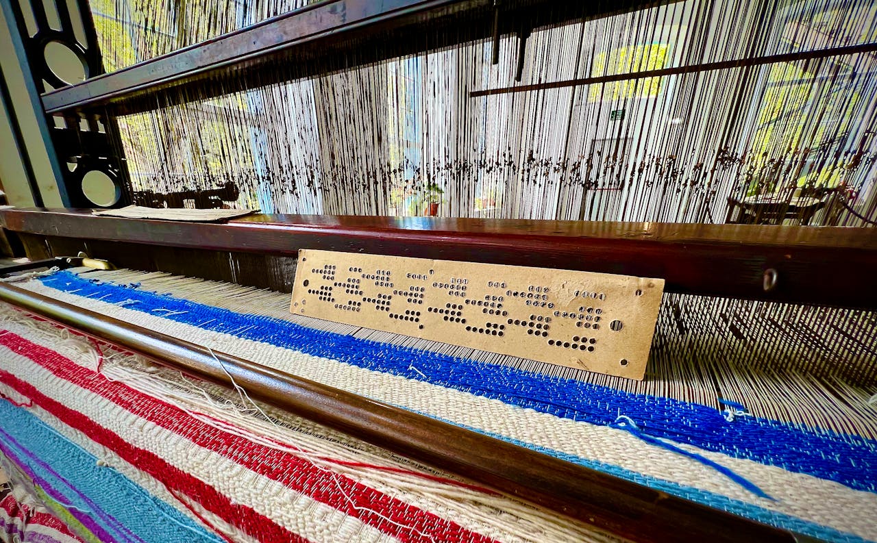 Detailed view of a traditional loom with colorful woven fabric in Balmaseda, Spain.